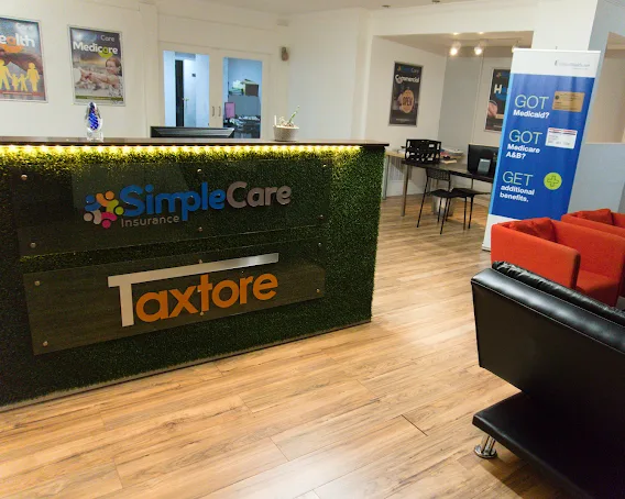 The front desk of the SimpleCare Insurance office in Miami, with its sign and the waiting area behind it.